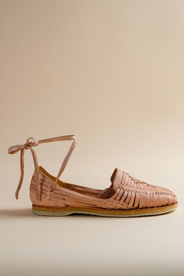 Brother Vellies woven flat huarache shoe with laces on a beige background