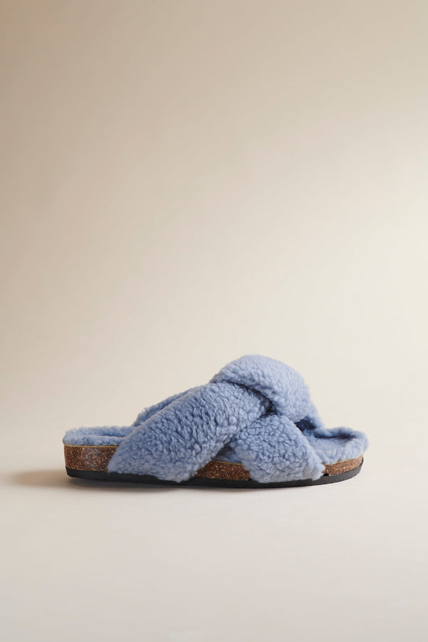 Brother Vellies Teddy Togo in Sky Blue is a shearling open-toed clog. Profile shown here on a beige background.