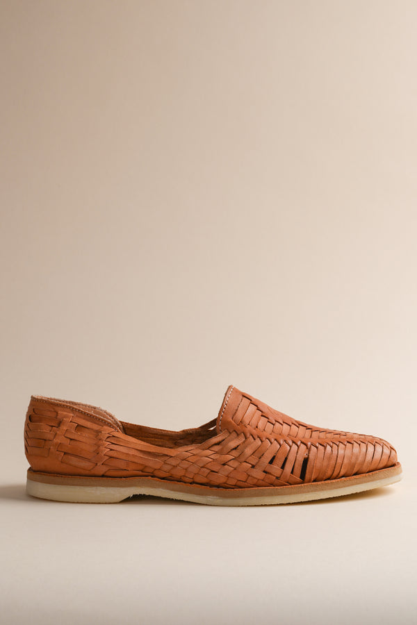 A single brown leather Huarache flat shoe against a neutral background.